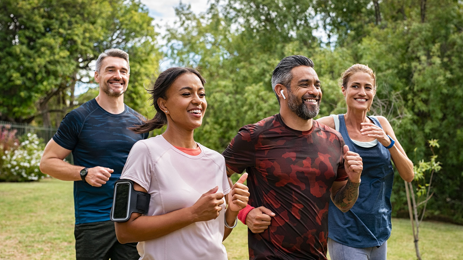 Four people jogging in park